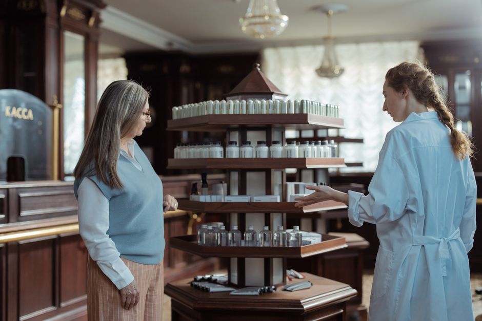 Farmacist care explică unui client dacă medicamentul este compensat